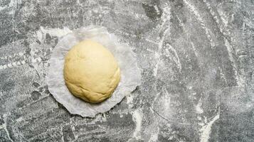 Fresh prepared dough on paper. On the stone table. photo