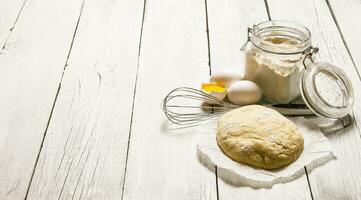 preparación de el masa. el preparado masa con el ingredientes - huevos, harina, agrio crema y batidor . foto