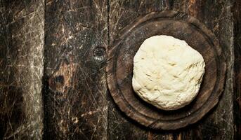 Dough background. Fresh dough on the old Board. On a wooden table. photo