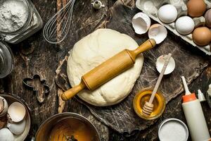 Dough background. Fresh dough with various ingredients on a wooden table. photo