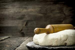 Fresh dough with rolling pin. photo