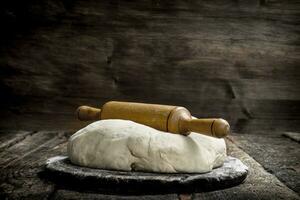 Fresh dough with rolling pin. photo