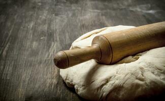 Fresh dough with a rolling pin. photo