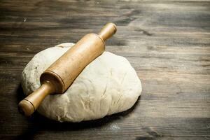 Fresh dough with a rolling pin. photo