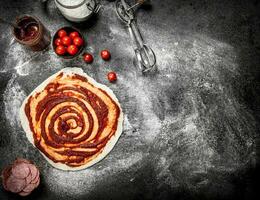 Roll up dough with tomato sauce and various ingredients. photo