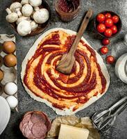 Roll up dough with tomato sauce and various ingredients. photo