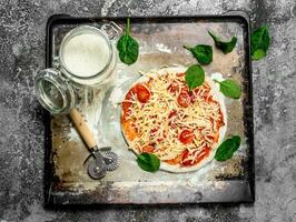 Unprepared pizza with ingredients. photo