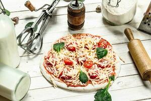 Preparation of pizza with various ingredients. photo