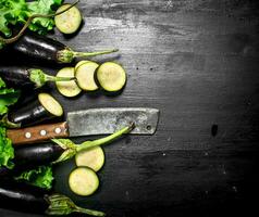 Fresh eggplants with an old knife and slices. photo
