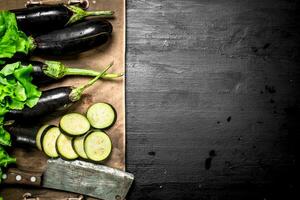 Fresh eggplants with an old knife and slices. photo