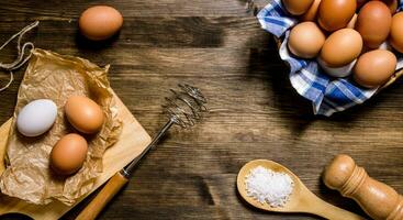 huevos el antecedentes. el huevos en el cuenco con el batidor. foto