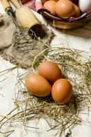 Eggs in a Cup with hay and tools - whisk, pestle. photo