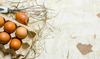 The cassette with eggs, hay and whisk . photo