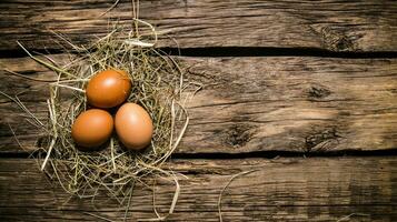 Eggs in the hay . On wooden table. photo