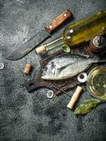 Fresh unprepared Dorado fish with white wine. photo