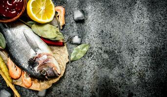 Fresh unprepared Dorado fish with sauce and spices. photo