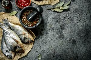 Fresh unprepared Dorado fish with sauce and spices. photo