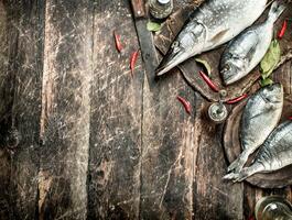 Raw Dorado fish with hot chili peppers. photo