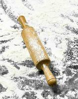 Flour with a wooden rolling pin. photo