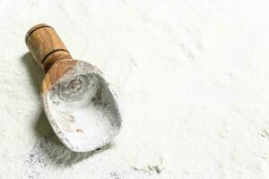 Flour with a wooden scoop. photo