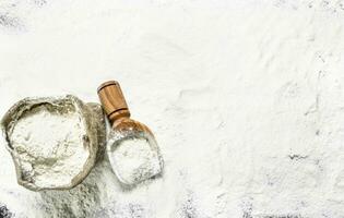 Flour in a bag with a wooden scoop. photo