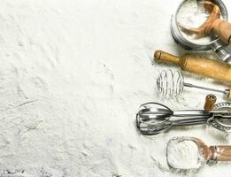 Various baking tools on flour. photo