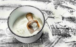 Flour with a shovel in a saucepan. photo
