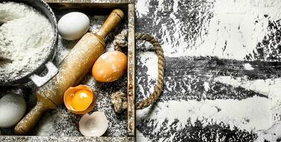 Dough backround. Flour with eggs and rolling pin. photo