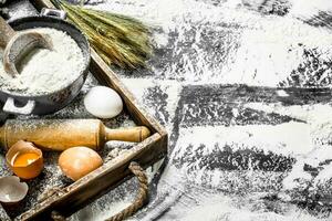 Dough backround. Flour with eggs and rolling pin. photo