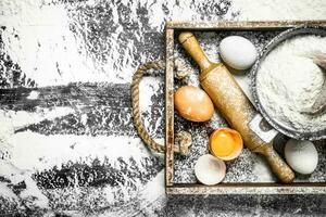 Dough backround. Flour with eggs and rolling pin. photo