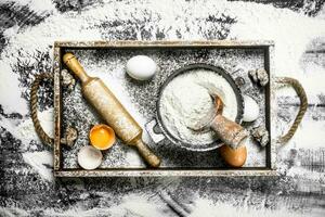 Dough backround. Flour with eggs and rolling pin. photo