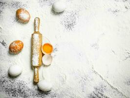 Rolling pin with fresh eggs photo