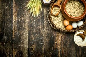 Flour with wheat grains on an old tray. photo