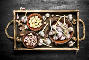 Fresh garlic in a bowl on a wooden tray. photo