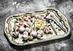 Fresh garlic on a steel tray with a press tool. photo