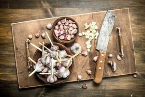 Sliced garlic cloves with an old knife. photo