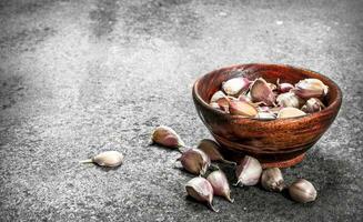 Peaces of fresh garlic in a wooden bowl. photo