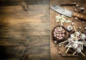 Sliced garlic cloves with an old knife. photo