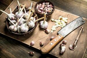 Sliced garlic cloves with an old knife. photo