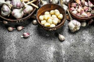 Peeled slices of fresh garlic in bowls. photo