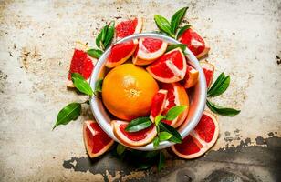 The grapefruit in a cup of sliced leaves. photo