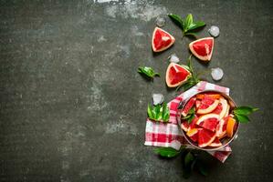 Cut the grapefruit with leaves in the bucket. photo