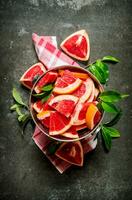 Cut the grapefruit with leaves in the bucket. photo