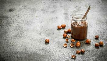 nut butter from hazelnuts and chocolate. On rustic background. photo