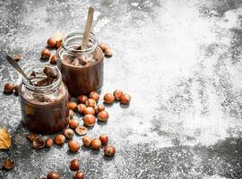 nut butter from hazelnuts and chocolate. On rustic background. photo