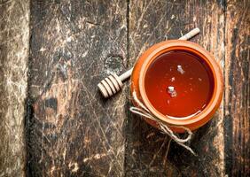 Honey pot with a wooden spoon. photo