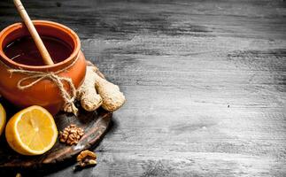 Honey background. Honey in pot with ginger and lemon. photo