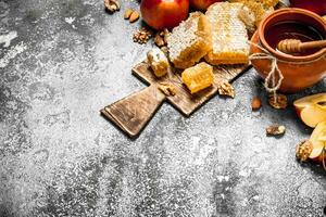 Honey background. Honey in pot with apples and nuts. photo