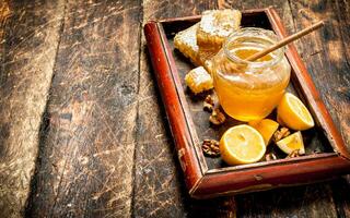 miel antecedentes . Fresco miel con limón y jengibre en un antiguo bandeja. foto