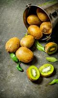 Fallen bucket with kiwi fruit and leaves. photo